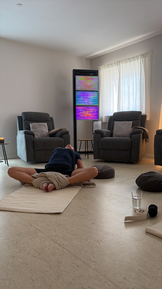 Yoga på gulvet foran skærmene